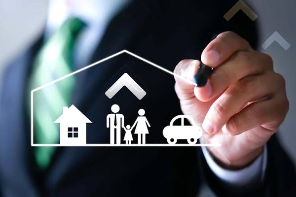 Pessoa desenhando ícones de casa, família e carro, representando o patrimônio familiar